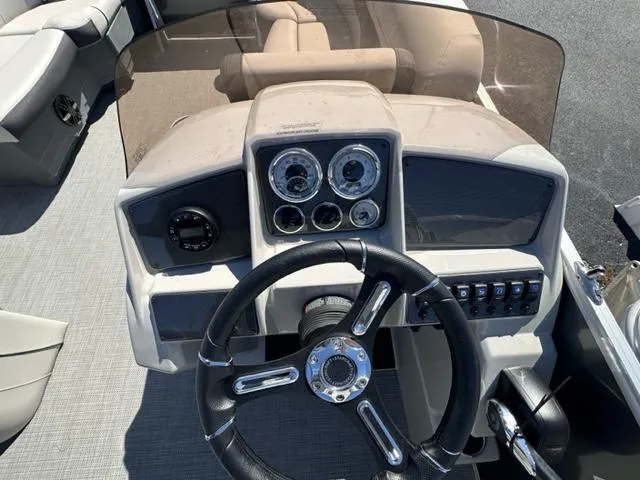 Slide: The Image of 2024 Starcraft EX 20 C boat dashboard with steering wheel and control panel. - 4