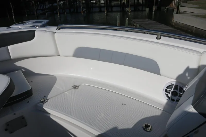 Slide: The Image of 2024 Robalo 222 Explorer CC boat interior seating area with white upholstery. - 14