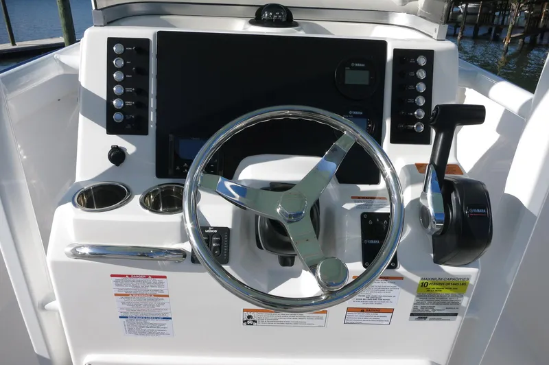 Slide: The Image of 2024 Robalo 222 Explorer CC helm with steering wheel and control panel. - 23