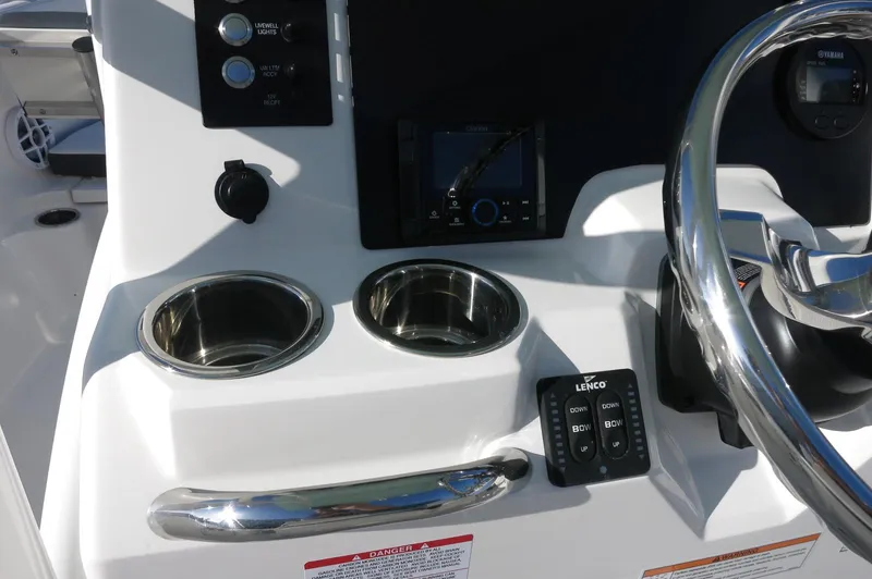 Slide: The Image of 2024 Robalo 222 Explorer CC helm with cup holders and controls. - 24