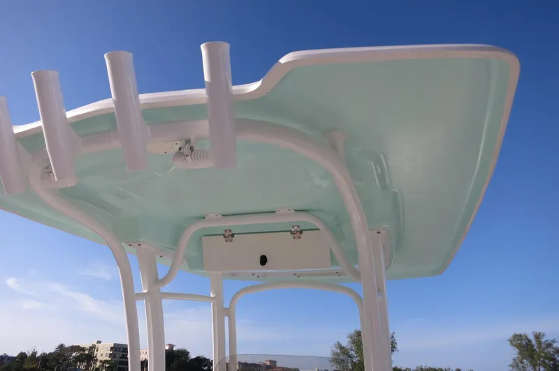 Slide: The Image of 2024 Robalo 222 Explorer CC T-top with rod holders against blue sky. - 26