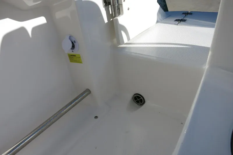 Slide: The Image of 2024 Robalo 222 Explorer CC boat interior detail showing clean, white deck and drainage system. - 29