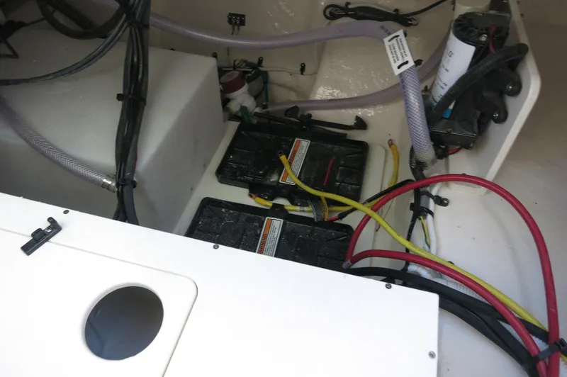 Slide: The Image of 2024 Robalo 222 Explorer CC boat battery compartment with wiring and components. - 35