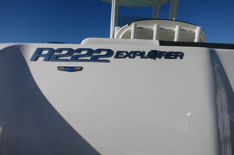 Slide: The Image of 2024 Robalo 222 Explorer CC boat model nameplate against blue sky. - 5