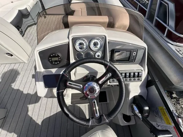 Slide: The Image of 2024 Starcraft EX 20 Q DH boat dashboard with steering wheel and control panel. - 5