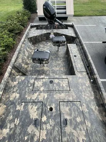 Slide: The Image of 2023 Crestliner 1760 Retriever Jon Deluxe boat with camo pattern and outboard motor. - 7