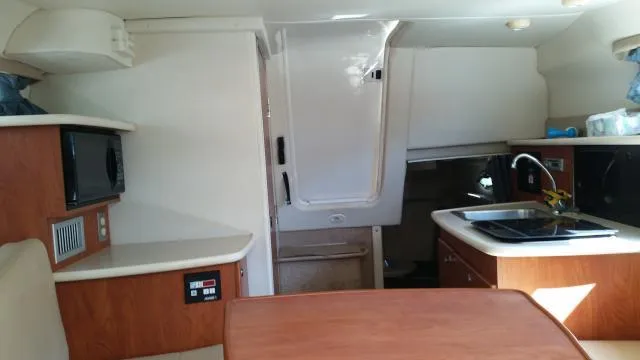 Slide: The Image of Interior of a 2005 Bayliner 265 boat with kitchenette and seating area. - 5