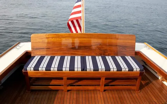 Slide: The Image of Wooden bench with striped cushions on a 2005 John Williams Custom 38 boat, American flag in background. - 10