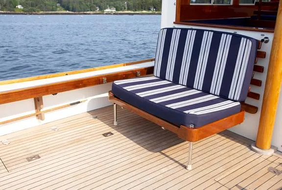 Slide: The Image of Striped cushioned seat on a 2005 John Williams Custom 38 boat deck by the water. - 12