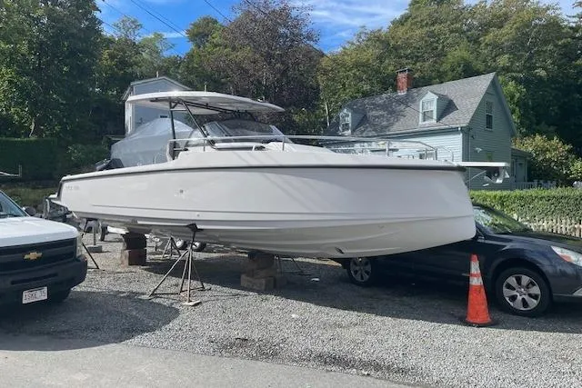 Slide: The Image of 2024 RYCK 280 boat on stands, parked outdoors near vehicles and houses. - 10