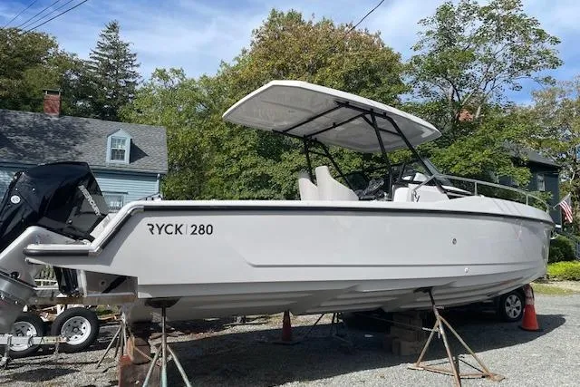 Slide: The Image of 2024 RYCK 280 boat on display outdoors, surrounded by trees and houses. - 11