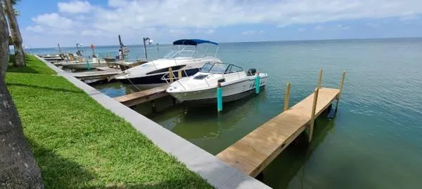 Slide: The Image of 1994 Bayliner Trophy boat docked by the shore on a sunny day. - 2