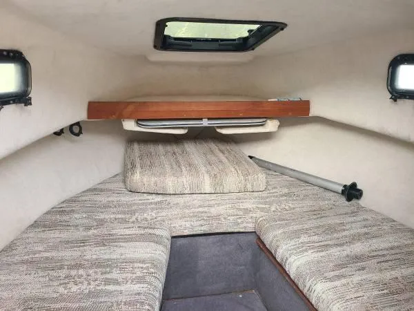 Slide: The Image of 1994 Bayliner Trophy cabin interior with cushioned seating and overhead storage. - 5