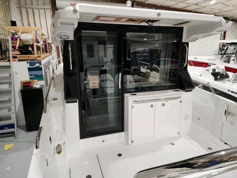 Slide: The Image of 2024 Wellcraft 355 Commuter boat interior with sliding glass door and storage cabinets. - 12
