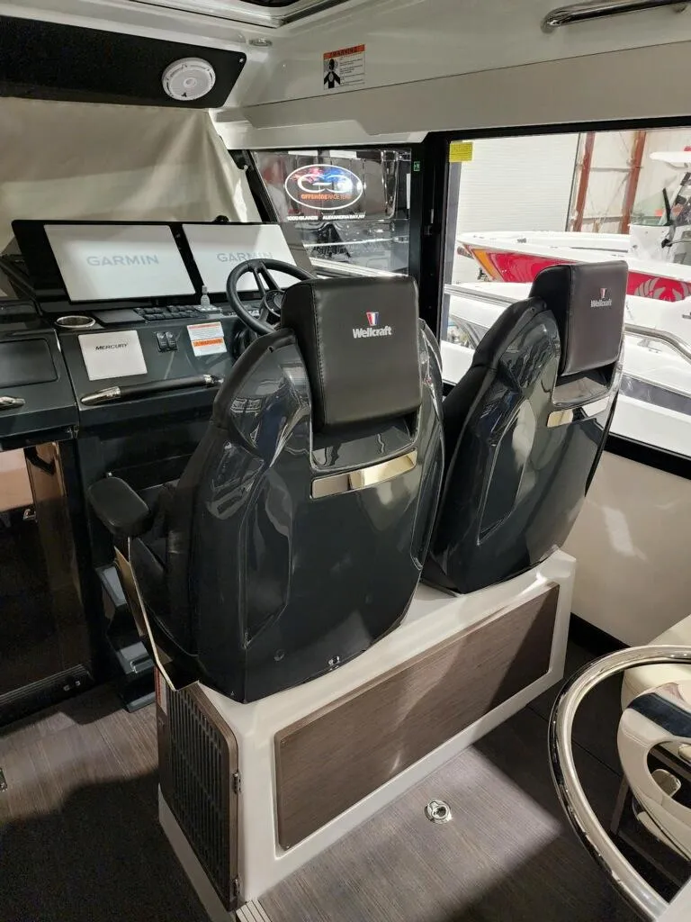 Slide: The Image of 2024 Wellcraft 355 Commuter boat interior with dual captain seats and navigation screens. - 27