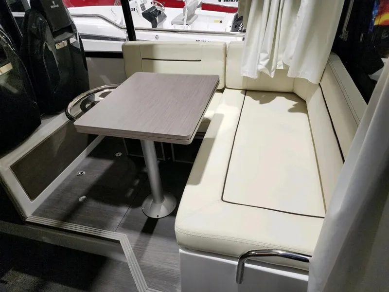 Slide: The Image of 2024 Wellcraft 355 Commuter interior seating area with table and cushioned bench. - 29