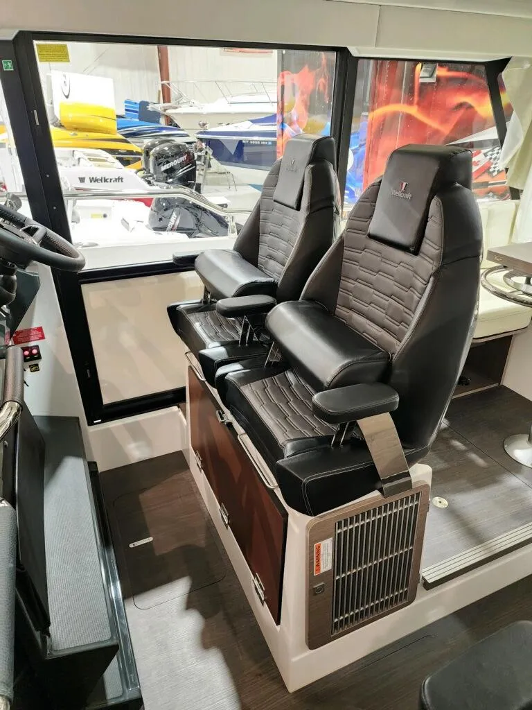 Slide: The Image of 2024 Wellcraft 355 Commuter boat interior with dual captain's chairs. - 32