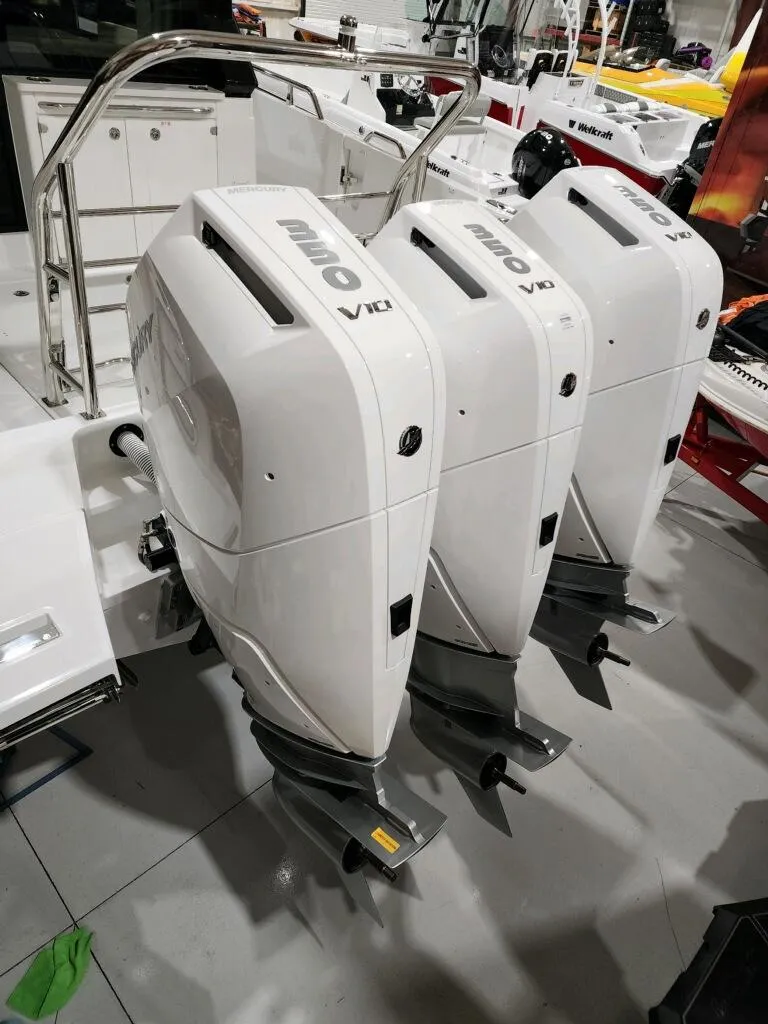 Slide: The Image of 2024 Wellcraft 355 Commuter with triple outboard engines in a showroom. - 9