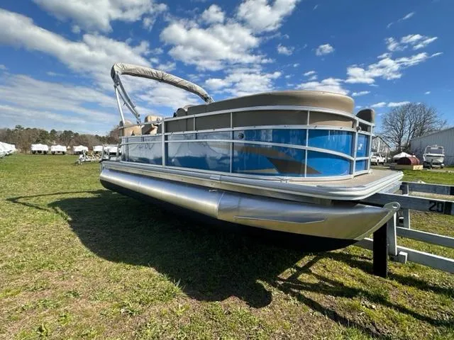 Slide: The Image of 2023 Starcraft LX 18 R pontoon boat on grassy field under blue sky. - 1