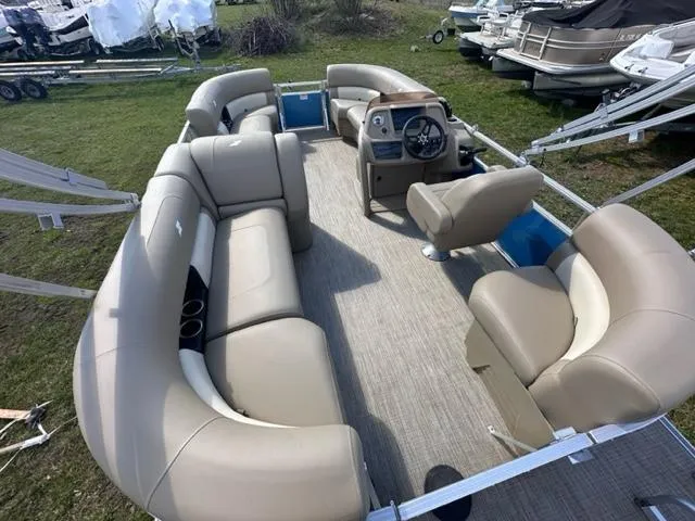 Slide: The Image of 2023 Starcraft LX 18 R pontoon boat interior with beige seating and steering console. - 4