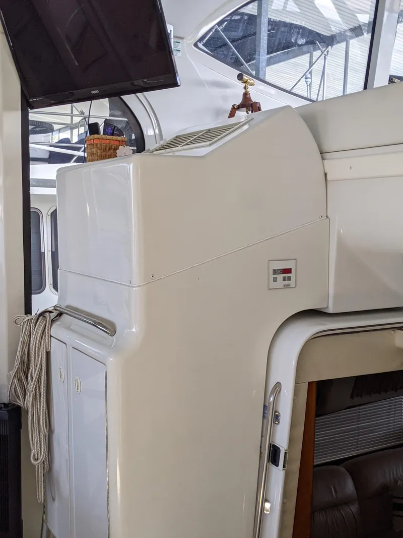 Slide: The Image of Interior of a 2000 Carver 506 Motor Yacht with white cabinetry and seating area. - 21