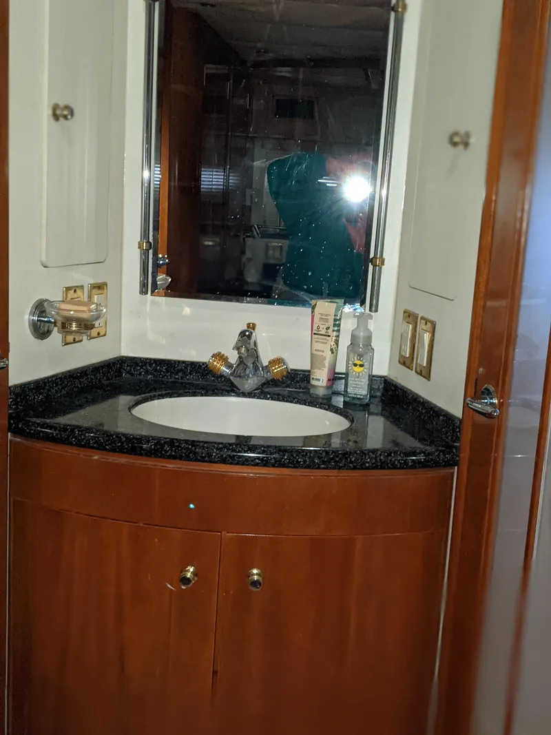 Slide: The Image of 2000 Carver 506 Motor Yacht bathroom with sink, mirror, and wooden cabinetry. - 25