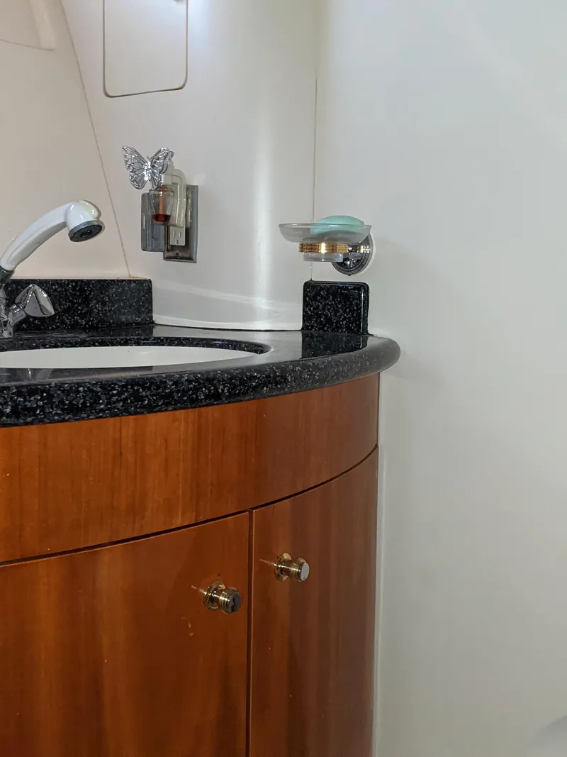 Slide: The Image of 2000 Carver 506 Motor Yacht bathroom sink with wooden cabinetry and modern fixtures. - 34