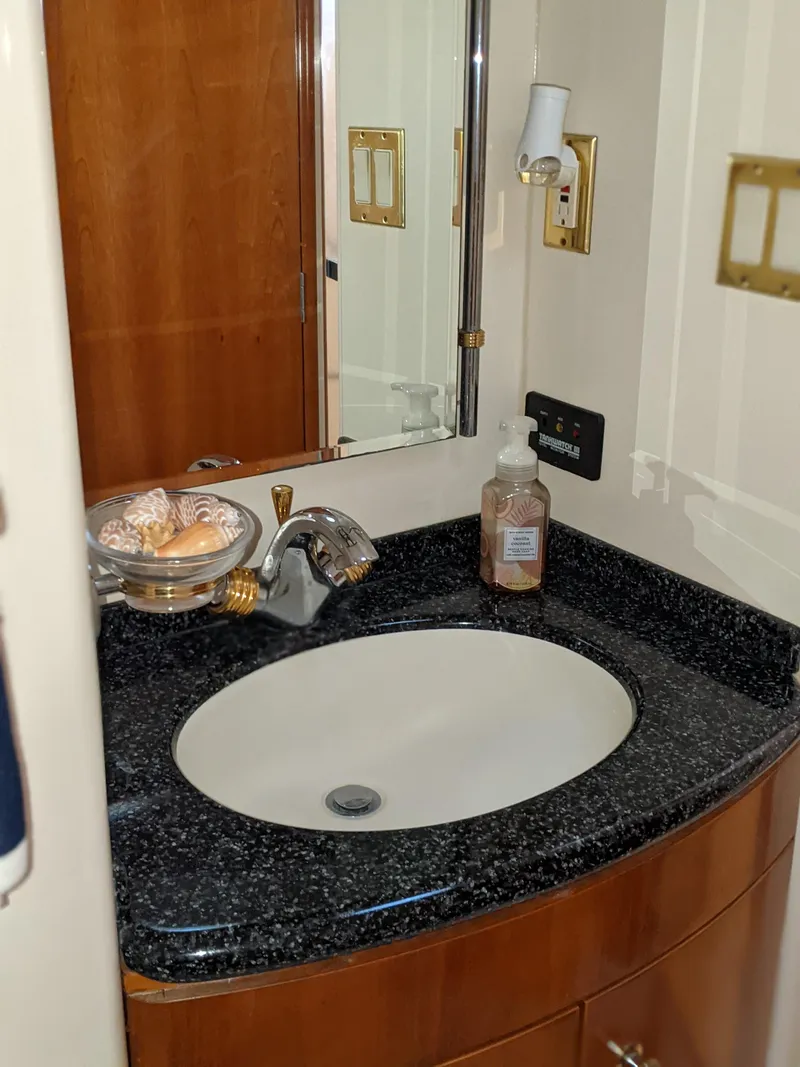 Slide: The Image of 2000 Carver 506 Motor Yacht bathroom sink with black countertop and wooden cabinetry. - 35