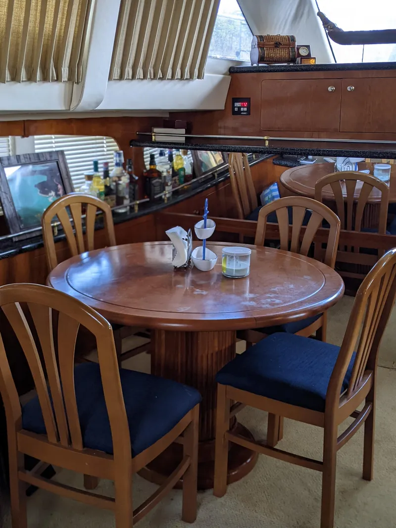 Slide: The Image of Dining area inside a 2000 Carver 506 Motor Yacht with wooden table and chairs. - 48