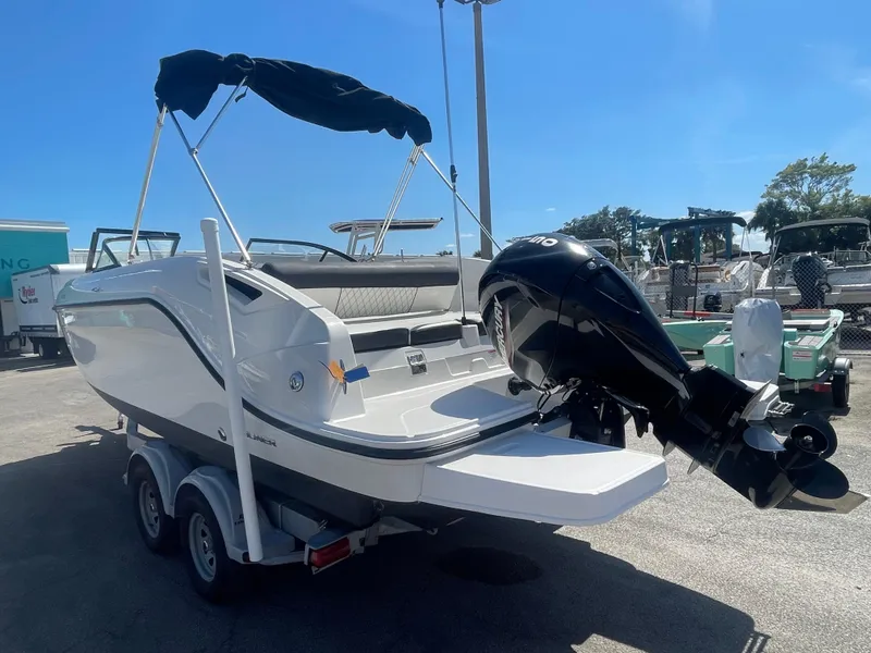Slide: The Image of 2021 Bayliner DX 2200 boat on trailer with outboard motor. - 3