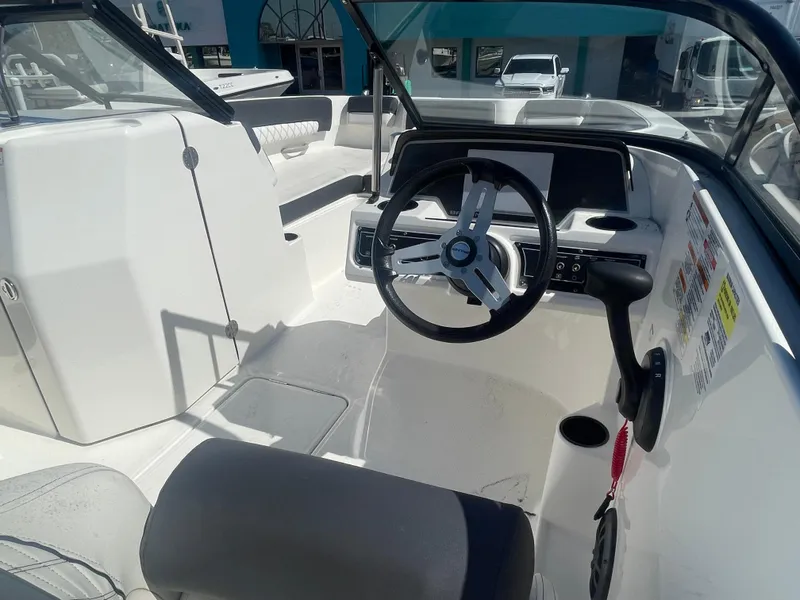 Slide: The Image of 2021 Bayliner DX 2200 boat cockpit with steering wheel and seating. - 5