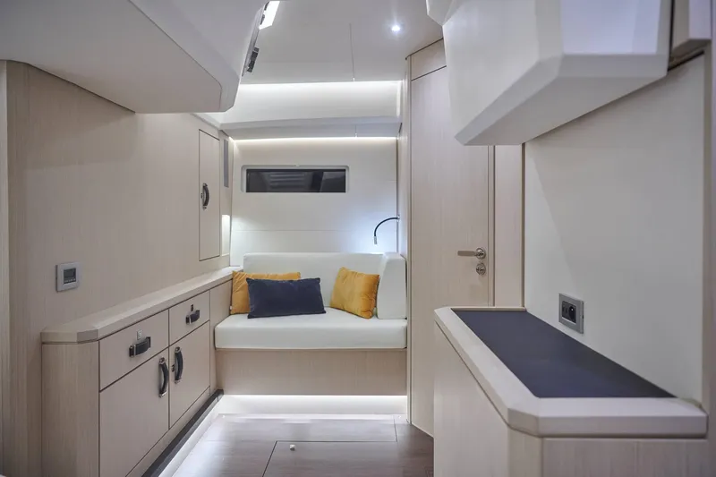Slide: The Image of 2024 Jeanneau 60 yacht interior with modern design, featuring a cozy seating area and ambient lighting. - 24