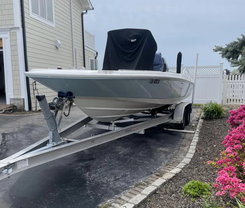 Slide: The Image of 2014 Boston Whaler 210 Dauntless boat on trailer, parked in driveway near flowers. - 4