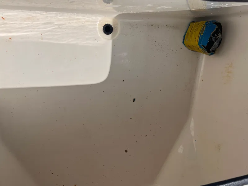 Slide: The Image of 2015 Triton 240 LTS boat interior with a small compartment and a battery. - 12