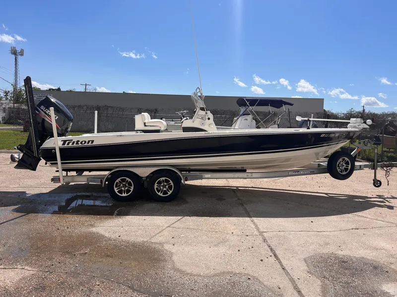 Slide: The Image of 2015 Triton 240 LTS boat on a trailer in a parking lot. - 6