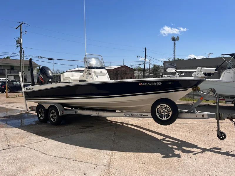 Slide: The Image of 2015 Triton 240 LTS boat on a trailer in a parking lot. - 7