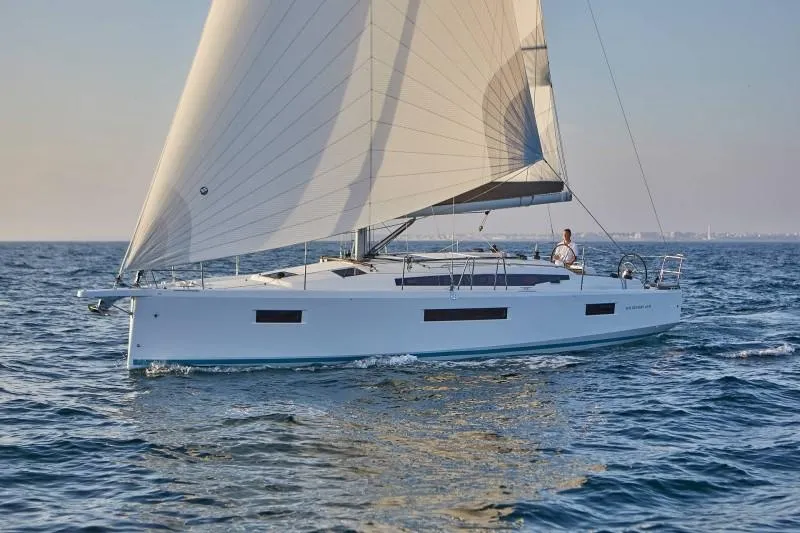Slide: The Image of 2025 Jeanneau Sun Odyssey 410 sailing on open water, showcasing sleek design and performance. - 2