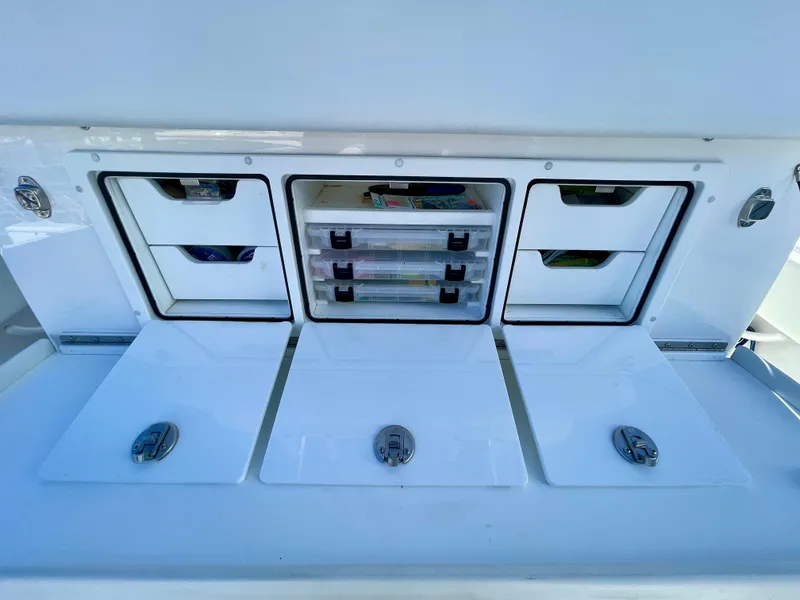 Slide: The Image of 2022 Invincible 39' Open Fisherman tackle storage compartments with organized drawers. - 20