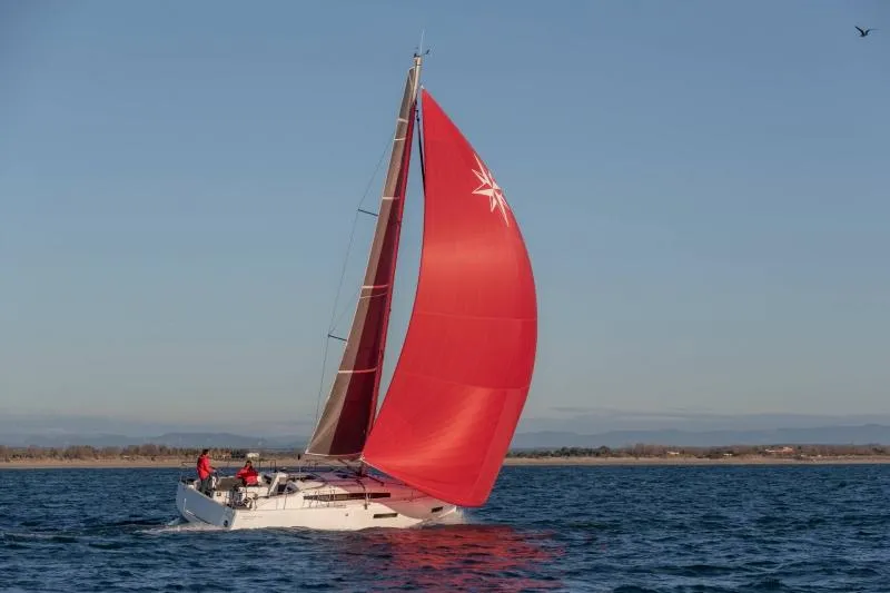 The Image of 2024 Jeanneau Sun Odyssey 380 sailing with vibrant red sail on open water. - 0