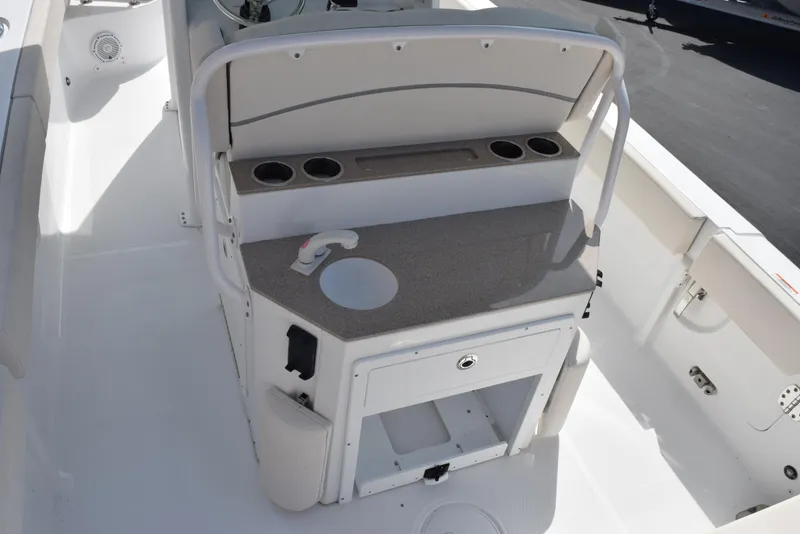 Slide: The Image of 2024 Sea Hunt Escape 25 boat interior with console, cup holders, and storage compartments. - 10