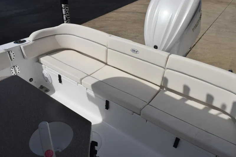 Slide: The Image of 2024 Sea Hunt Escape 25 boat with white cushioned seating and outboard motor. - 11