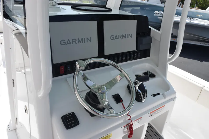 Slide: The Image of 2024 Sea Hunt Escape 25 boat dashboard with dual Garmin displays and steering wheel. - 12