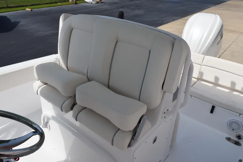 Slide: The Image of 2024 Sea Hunt Escape 25 boat with comfortable white seating and steering wheel. - 14