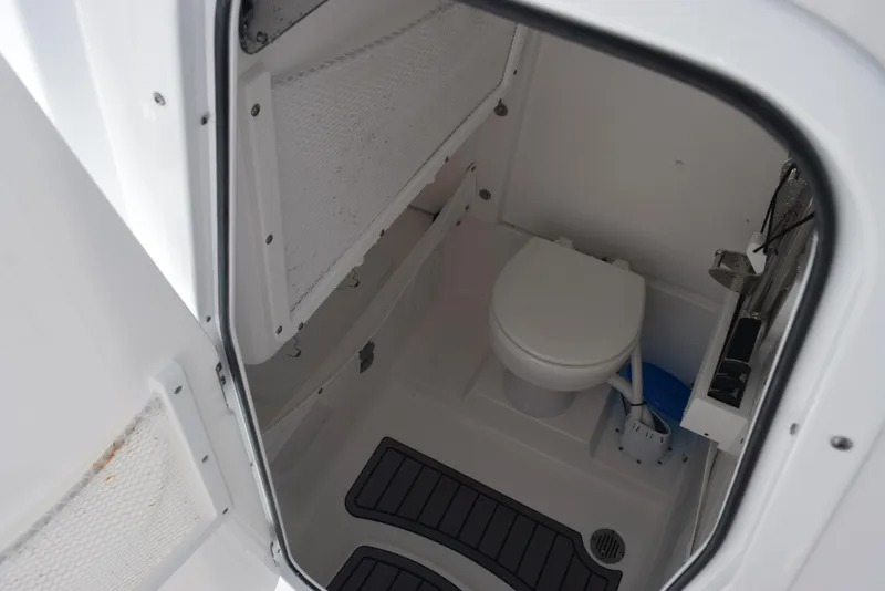 Slide: The Image of 2024 Sea Hunt Escape 25 boat interior bathroom with toilet and storage. - 19