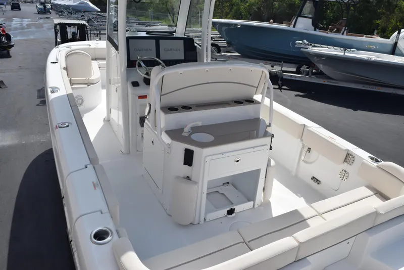 Slide: The Image of 2024 Sea Hunt Escape 25 boat interior with seating and console, docked outdoors. - 8