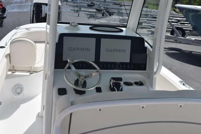 Slide: The Image of 2024 Sea Hunt Escape 25 boat dashboard with dual Garmin displays and steering wheel. - 9