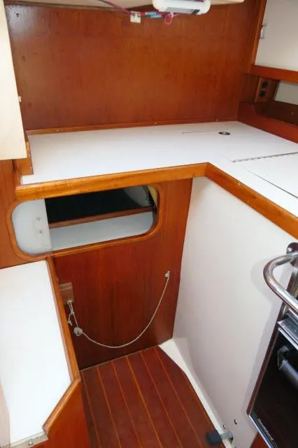 Slide: The Image of Interior of 1991 Catalina 36 sailboat with wooden cabinetry and white countertops. - 14