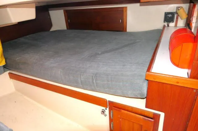 Slide: The Image of Cozy sleeping quarters in a 1991 Catalina 36 sailboat with wooden cabinetry. - 23