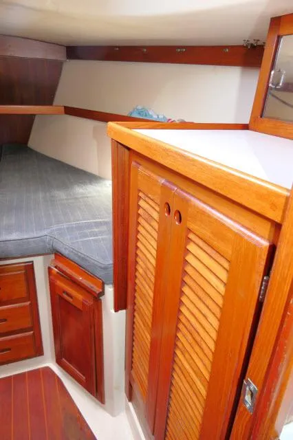 Slide: The Image of Interior cabin of a 1991 Catalina 36 sailboat with wooden cabinetry and a cushioned berth. - 28