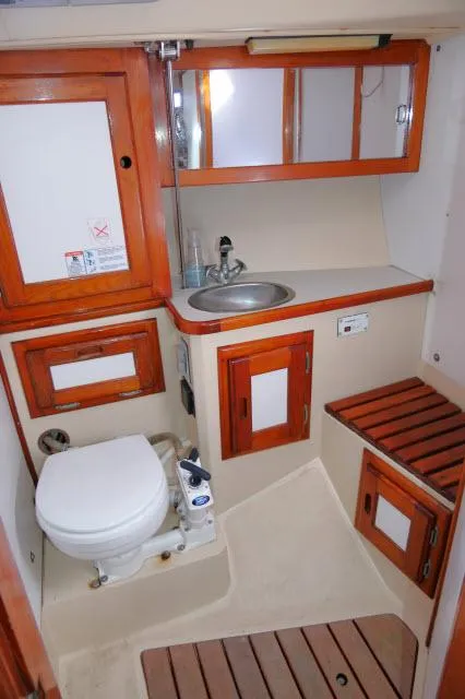 Slide: The Image of 1991 Catalina 36 sailboat bathroom with sink, toilet, and wooden cabinets. - 30